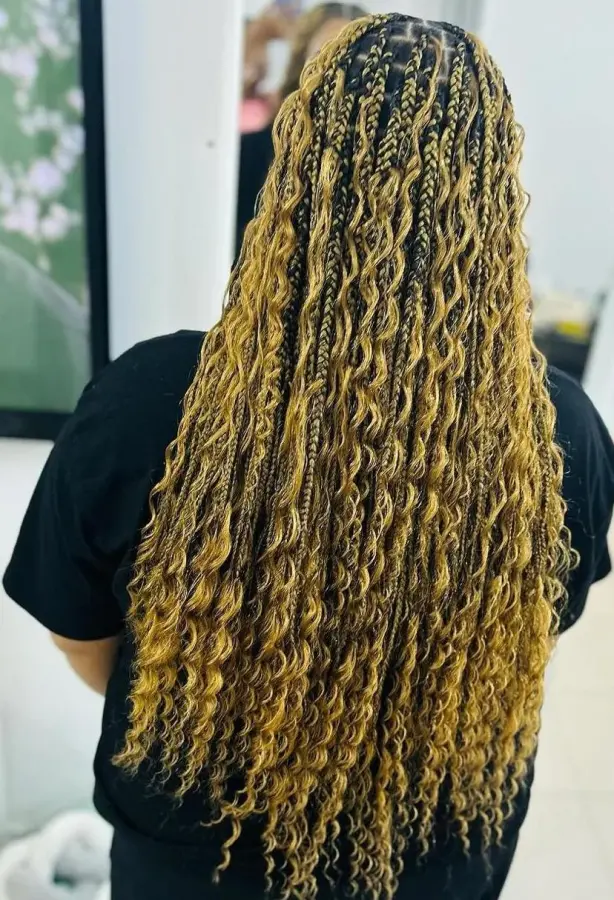 Back view of long blonde and honey boho braids with curly ends, in the salon